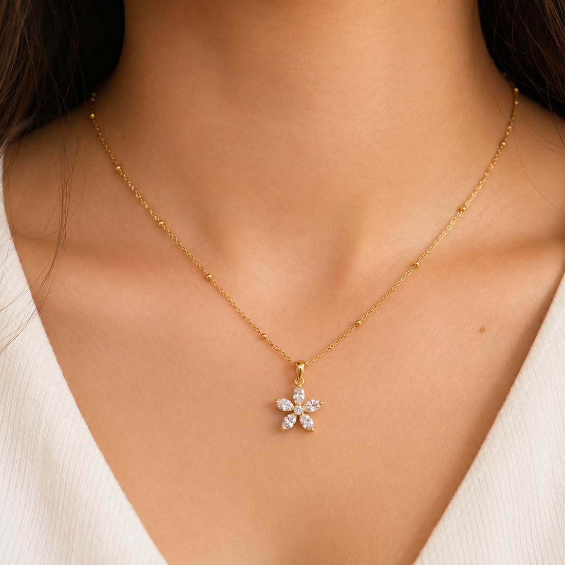 Gold necklace with pink gemstone pendant on a black cushion