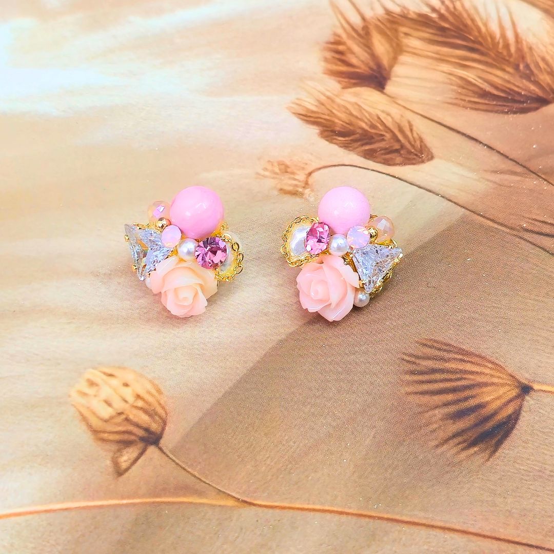 Shimmera earrings in a box on a wooden surface with flowers in the background