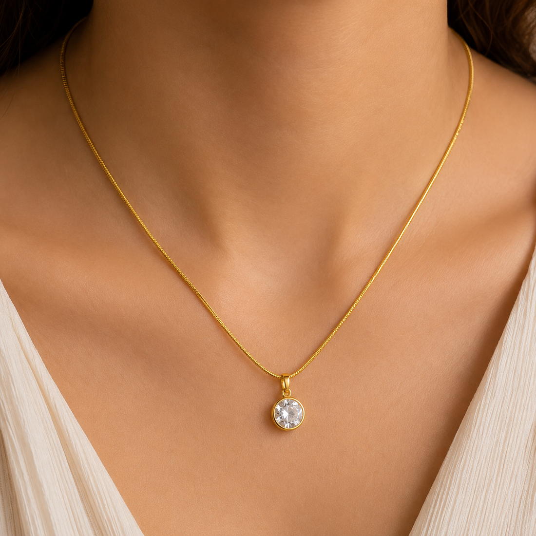 Gold necklace with a pendant on a Shimmera branded stand