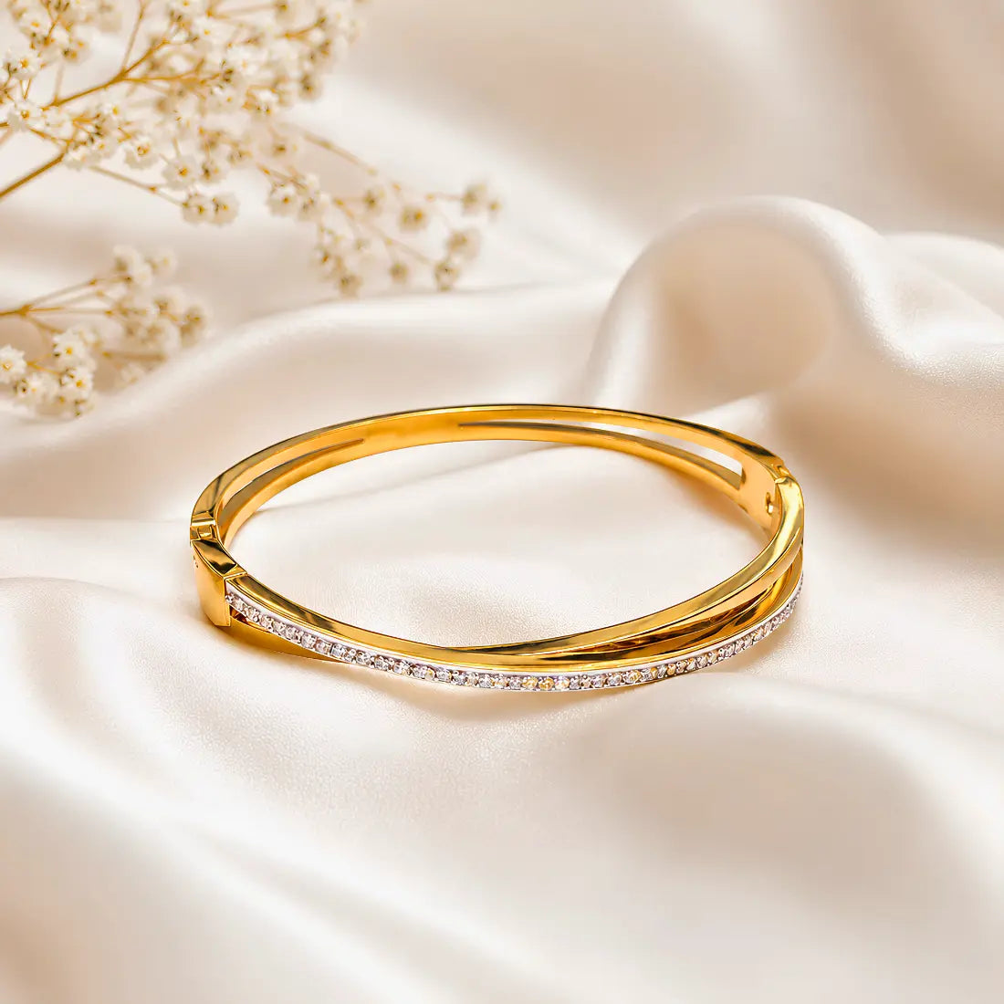 Gold bracelet with small diamonds on a soft beige fabric background
