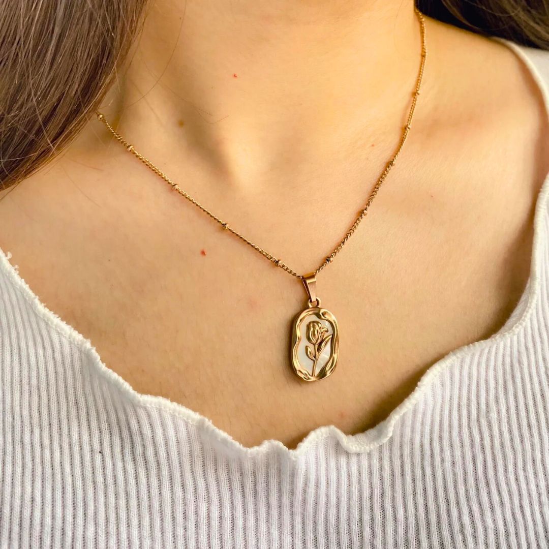 Gold necklace with a pendant on a Shimmera branded box on a wooden surface