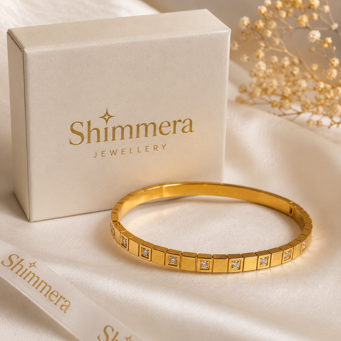 Gold bracelet with 'Shimmera Jewellery' box and packaging on a beige background